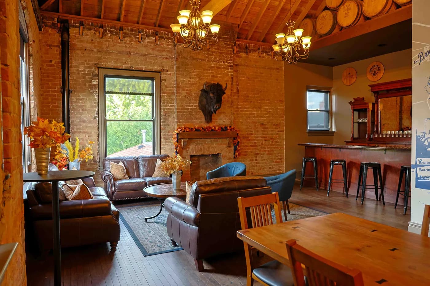 The Boardroom's own bar along the back wall, with the sitting area and fireplace in front of it