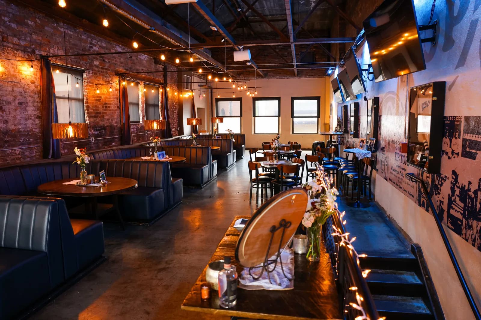 The Clubhouse set for a private party, booths dressed with flowers and string lights overhead